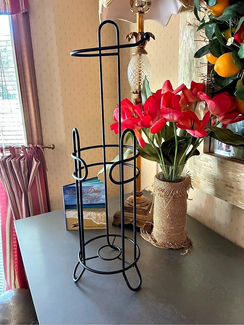 Freestanding BLACK metal toilet paper holder featuring a top dispensing arm.